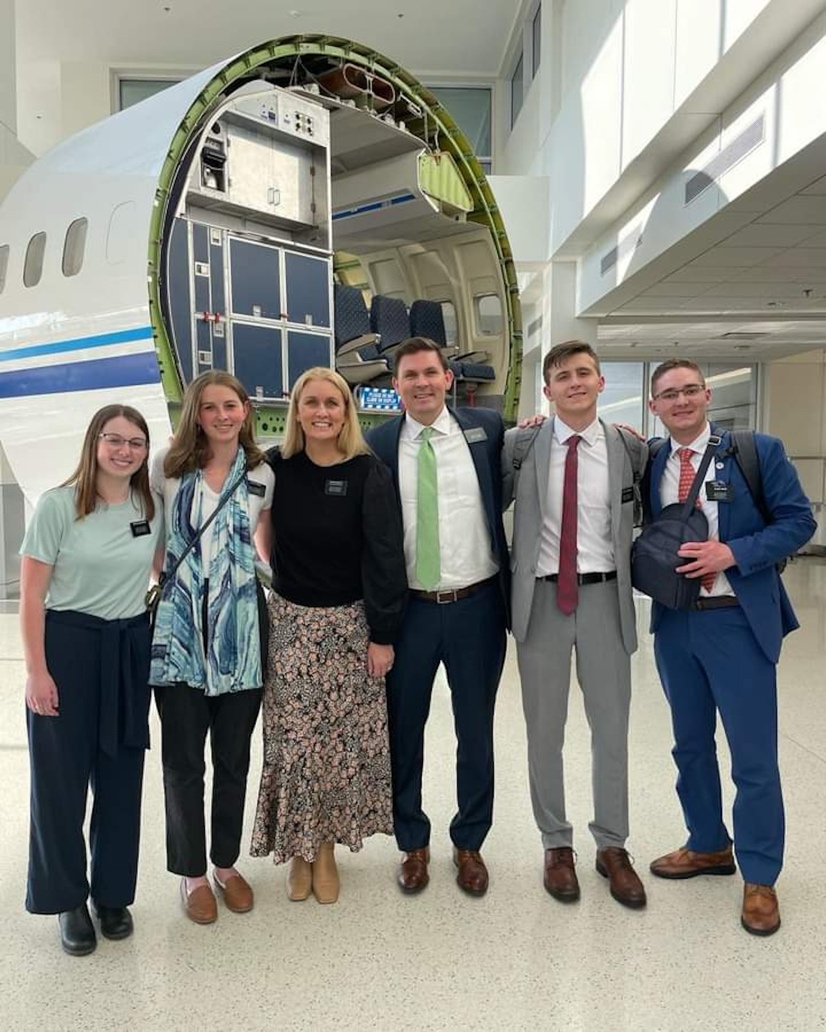 A group of people standing in front of an airplane

AI-generated content may be incorrect.