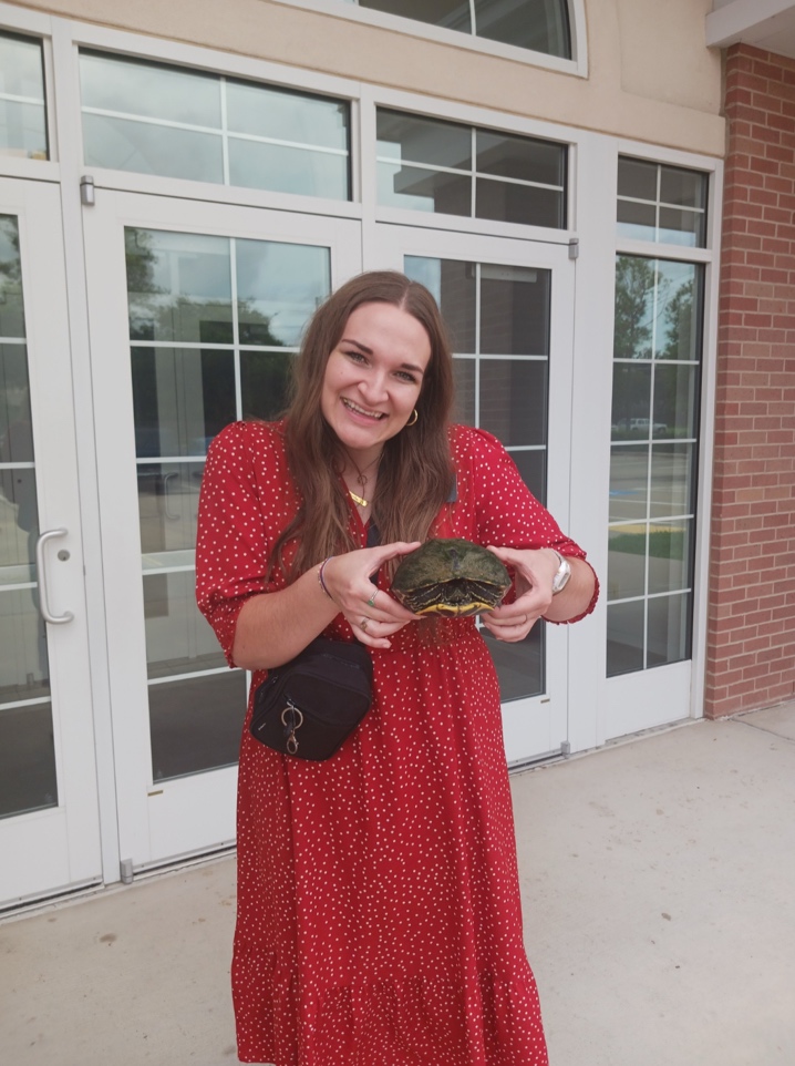A person in a red dress holding a turtle

AI-generated content may be incorrect.
