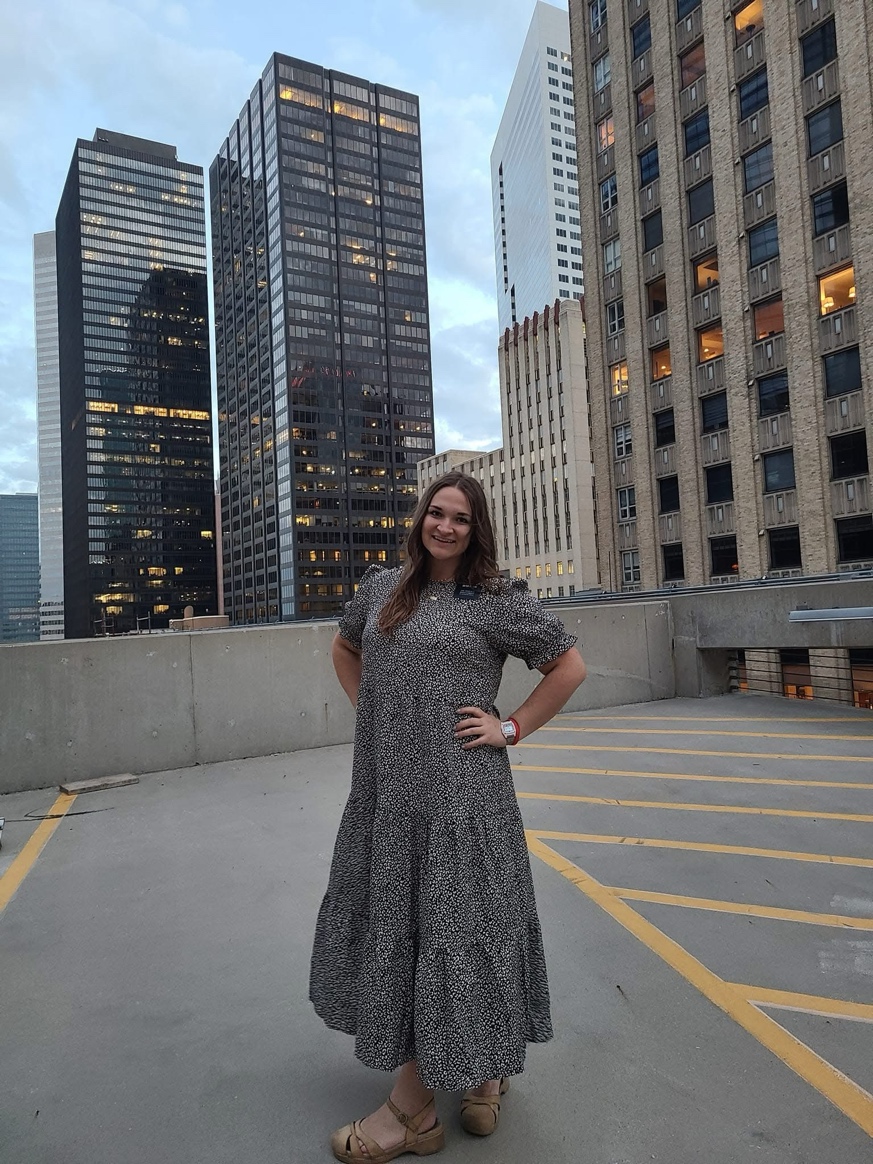 A person standing in a parking lot with buildings in the background

AI-generated content may be incorrect.